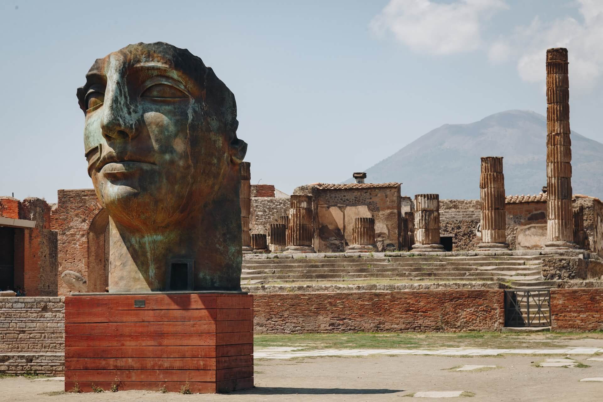 a statue of a woman's head in front of the ruins