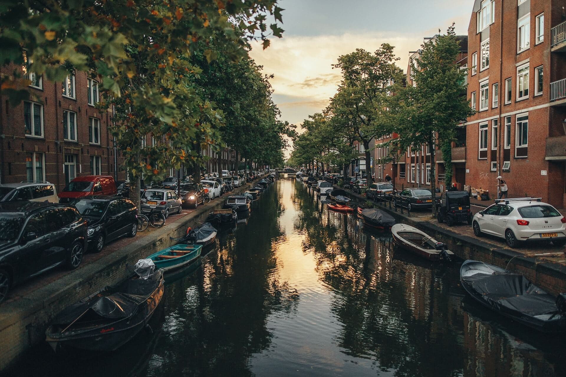 a canal with boats and cars