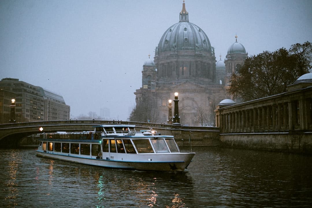 a boat traveling down a river next to a bridge