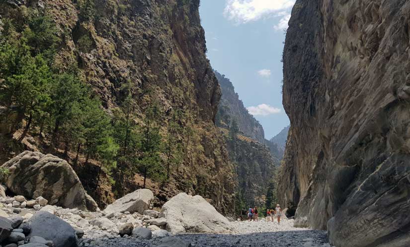 a couple of people standing on a rocky river