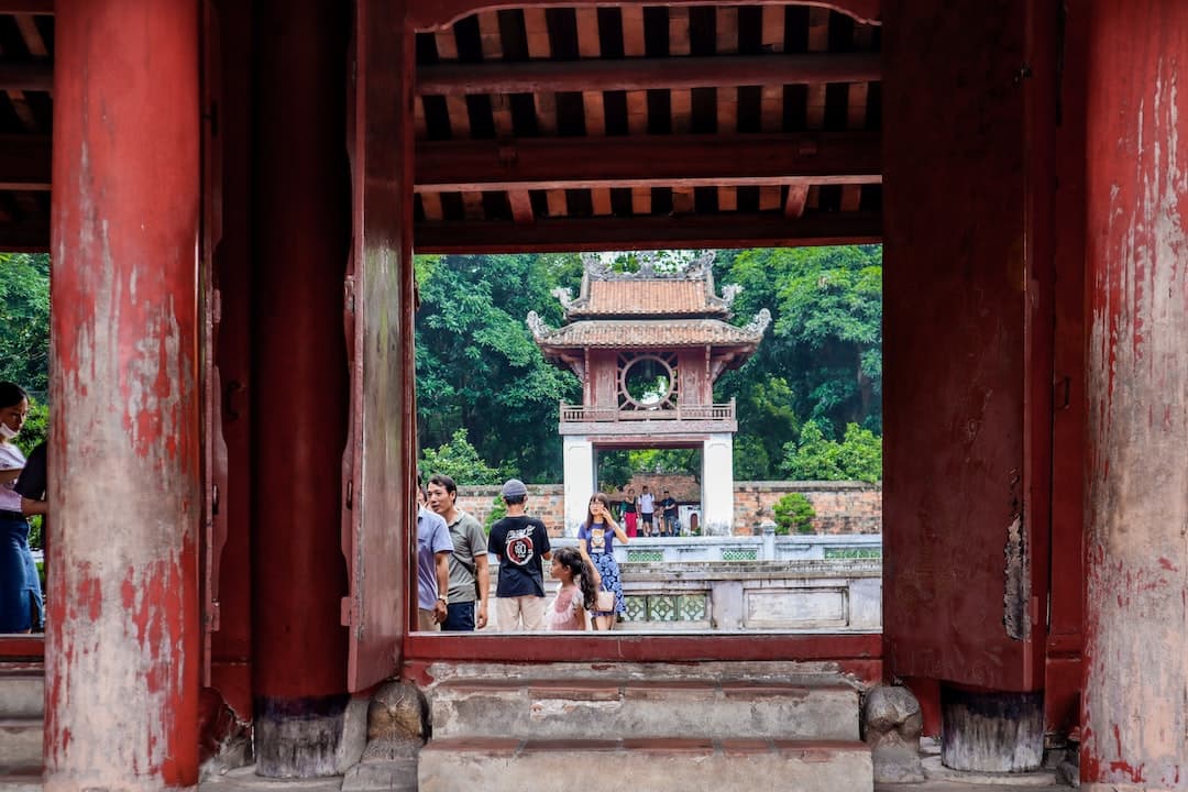 a group of people standing around a red building