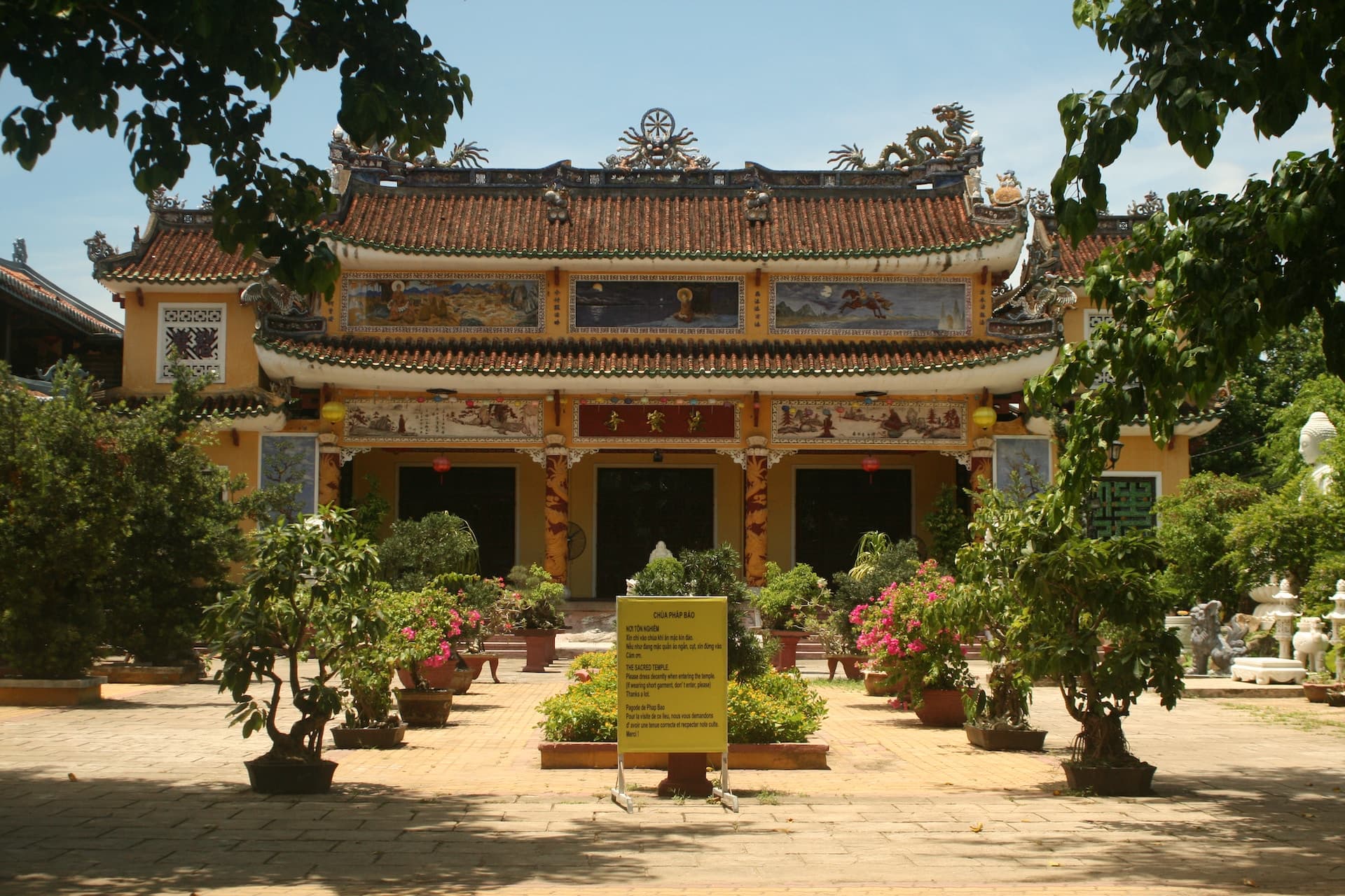 a yellow building with a tree in front of it