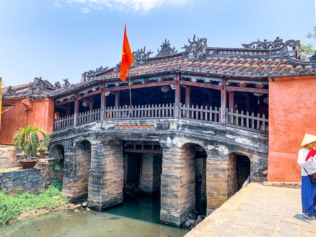 a woman standing on a bridge over a body of water