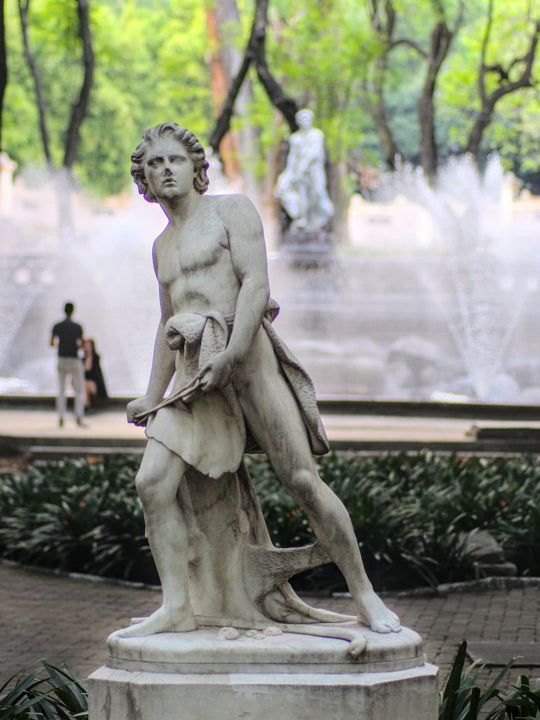 a statue of a man standing in front of a fountain