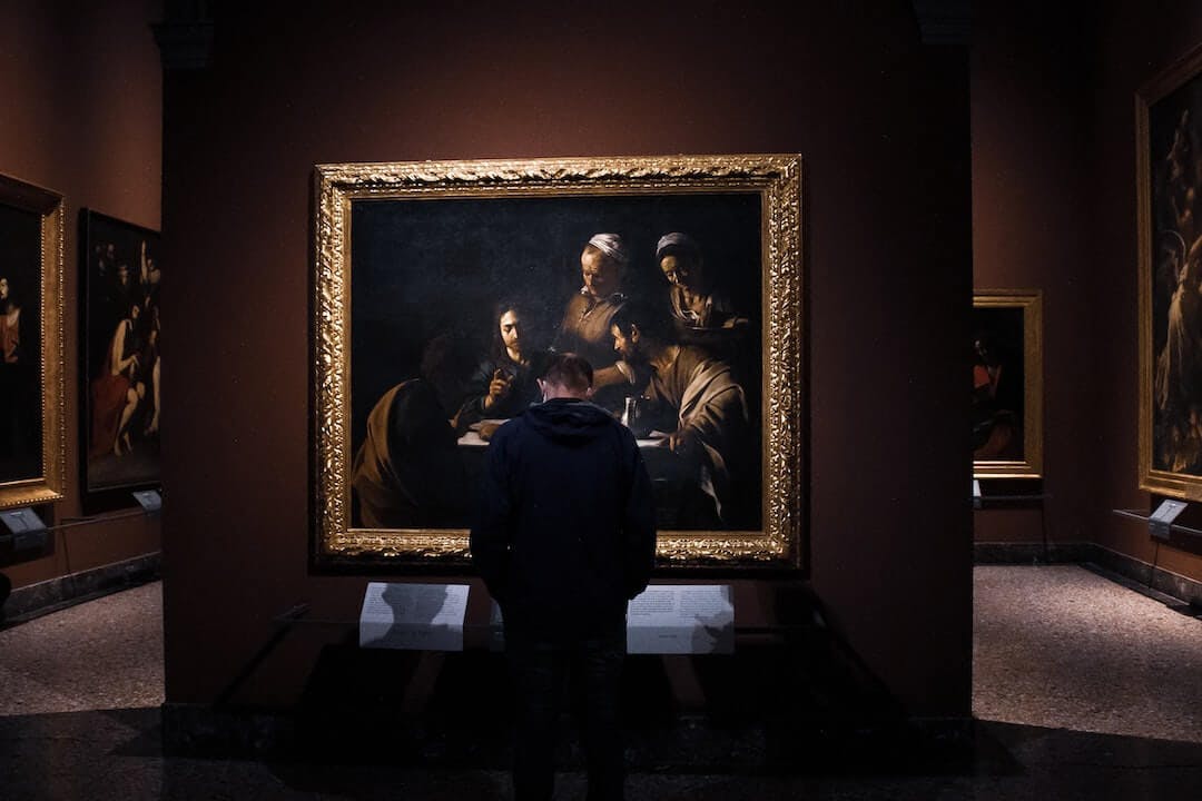 a man standing in front of a painting in a museum
