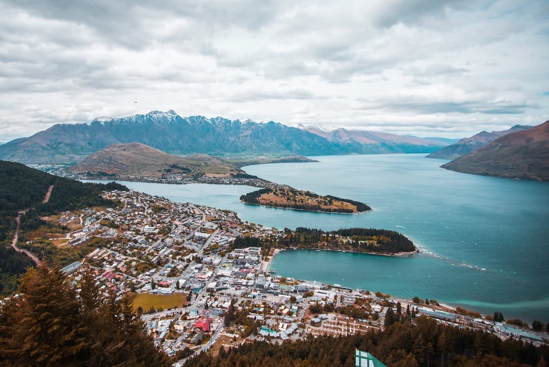 aerial photography of white houses near body of water under white clouds at daytime