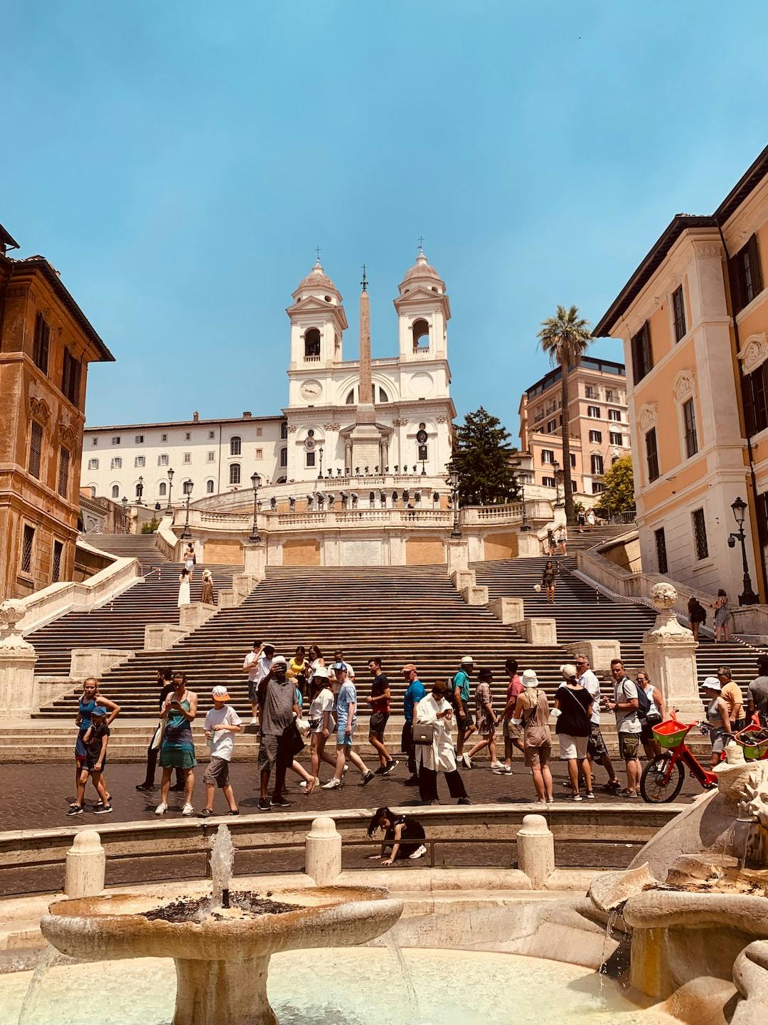 a group of people walking up stairs with Spanish Steps in the background