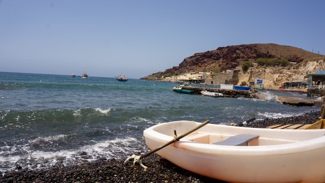 white boat on shore during daytime