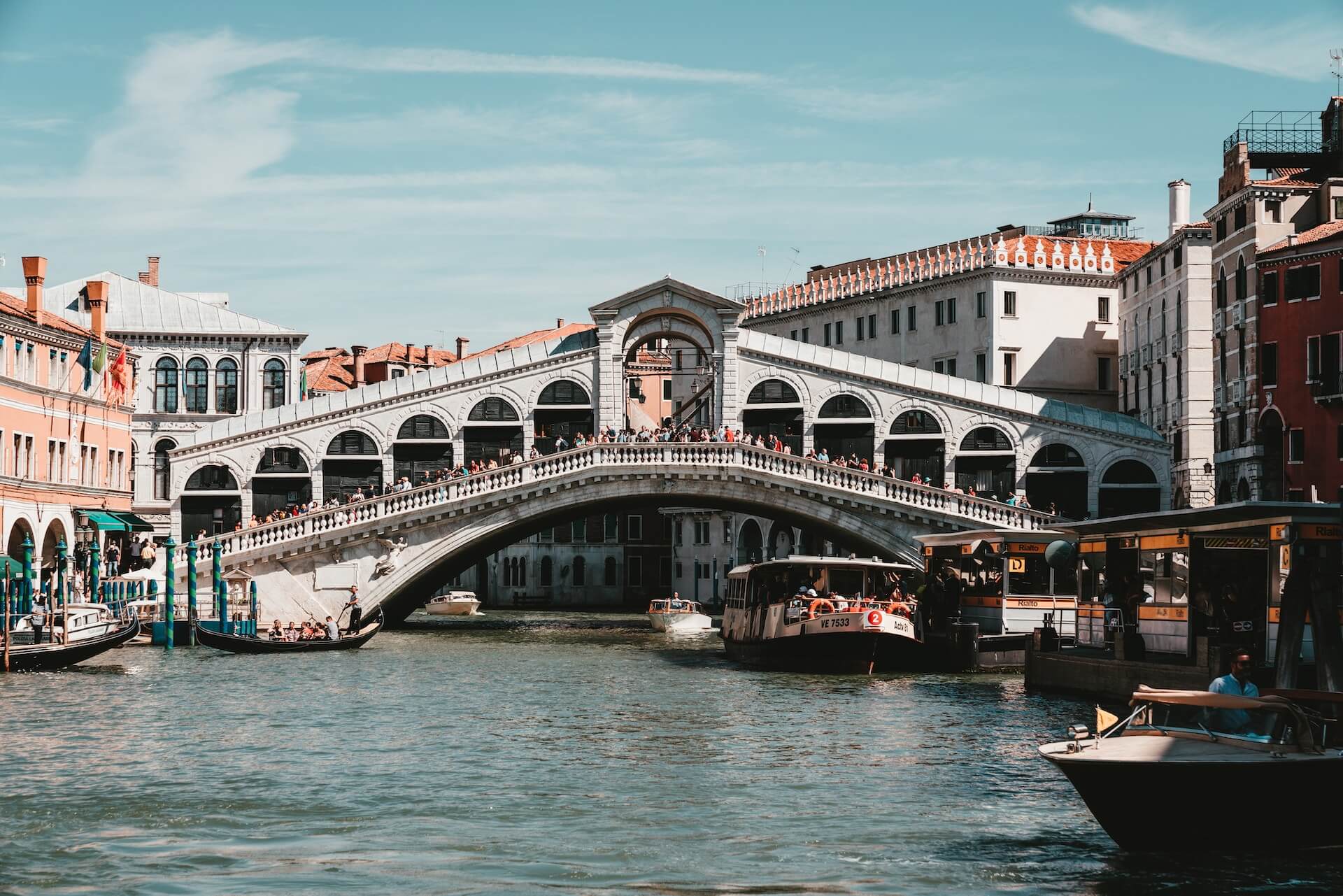 photo of gondolas on body of water between buildings